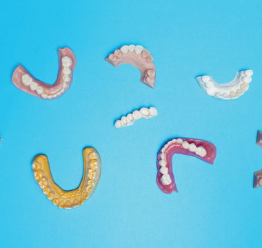 Blue background and 3D printed models, dentures and crowns