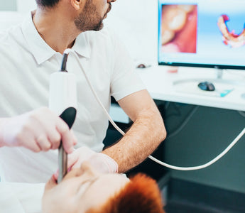 Dentist scanning patient's mouth and scan screen is visible