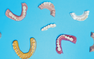 Blue background and 3D printed models, dentures and crowns