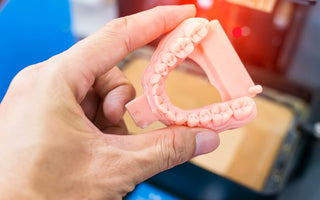3D printed dental model with 3D printer in the background
